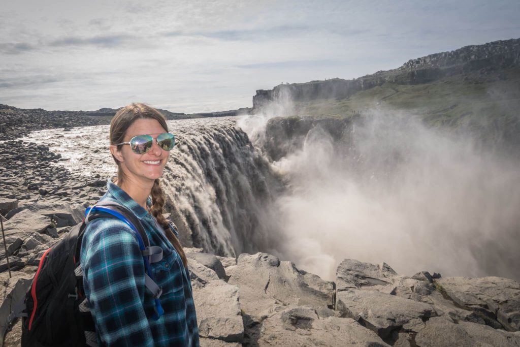 woman standing at top of Dettifoss waterfall